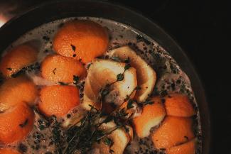 a pot filled with oranges and herbs by Krystal Black courtesy of Unsplash.