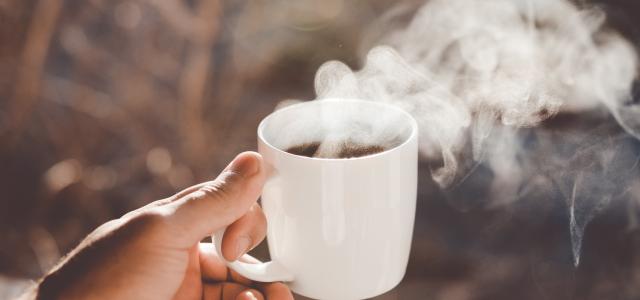 person holding white ceramic cup with hot coffee by Clay Banks courtesy of Unsplash.