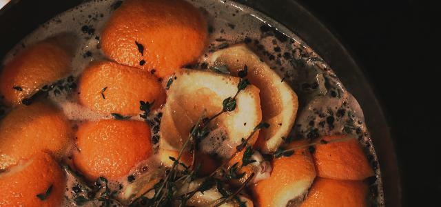 a pot filled with oranges and herbs by Krystal Black courtesy of Unsplash.